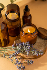 Soy candles in a glass jar. Aromatherapy. Burning candle and lavender. Wooden lid for jars. Beige...