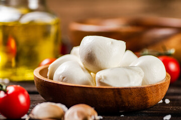 Mozzarella cheese on a plate on a table with tomatoes and spices. 