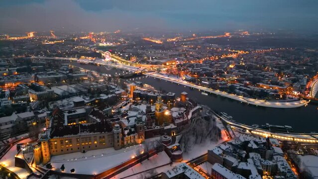 Wawel castle and Vistula River in Krakow, Poland in winter, night aerial shot