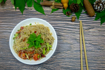 Rice noodles spicy salad with fermented fish thai food served on a wooden table is eating main dish or snacks available.