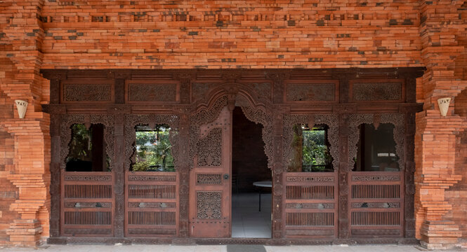 Gebyok is surrounded by brick walls. Gebyok is one of the typical Javanese furniture, which is generally made of teak wood. Used for the door of the house. One of the two doors is opened.