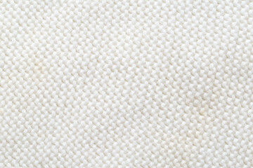 Comfortable warm knitted sweater made of white threads, background. Macro, handmade