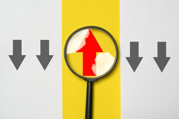 Magnifier glass with red up arrow which different direction black arrow for focus business...