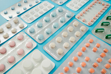 Pharmaceutical drugs, antibiotics, pills. Colorful pills on a blue background, capsule pills