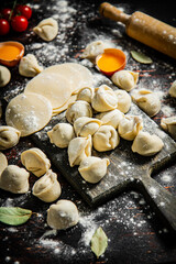 Raw dumplings with flour, eggs and cherry tomatoes. 