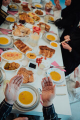 Top view of Muslim family having Iftar dinner drinking water to break feast. Eating traditional food during Ramadan feasting month at home. The Islamic Halal Eating and Drinking in modern home 