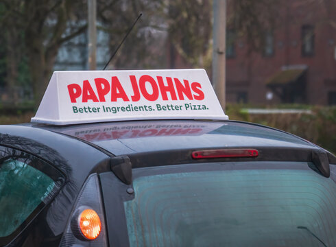 papa johns pizza sign over a car in Bristol England