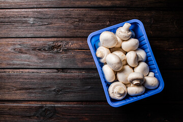 Mushrooms in a plastic box on the table. 
