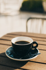 Cup of black coffee on a table in a street cafe.
