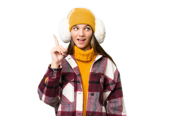 Teenager caucasian girl wearing winter muffs over isolated background intending to realizes the solution while lifting a finger up