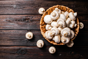 Basket with fresh mushrooms. On a wooden background. 