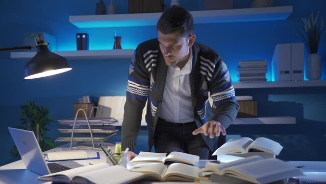 Concentrated senior male researcher working in study room late at night.
The young researcher reading a book wants to reveal the truth about the subject he is interested in.
