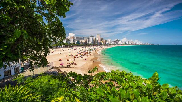 A timelapse of beachgoers in Rio de Janeiro, Brazil playing on the sand and in the water of the Atlantic Ocean at Leblon, near Ipanema and Copacabana.