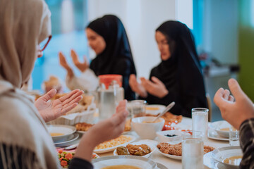 A Muslim family praying together, the Muslim prayer after breaking the fast in the Islamic holy month of Ramadan
