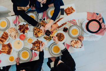  Muslim family having Iftar dinner drinking water to break feast. Eating traditional food during Ramadan feasting month at home. The Islamic Halal Eating and Drinking in modern home 
