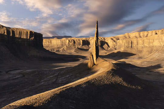 Sharp rock formations in mountainous valley under sunset sky