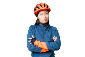 Young cyclist woman over isolated chroma key background making doubts gesture while lifting the shoulders