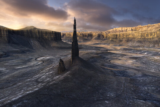 Sharp rock formations in mountainous valley under sunset sky