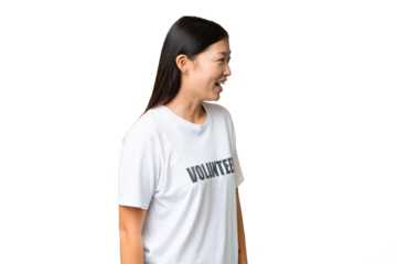 Young volunteer woman over isolated chroma key background laughing in lateral position