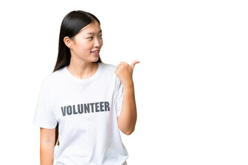 Young volunteer woman over isolated chroma key background pointing to the side to present a product