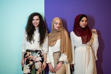 Group portrait of beautiful muslim women two of them in fashionable dress with hijab isolated on...