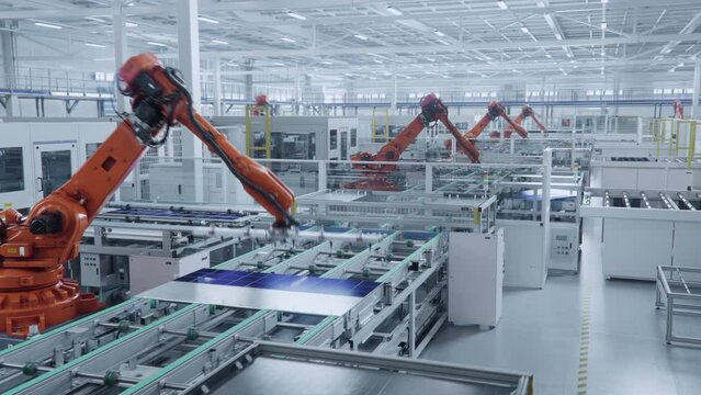Time-lapse of Automated Solar Panel Production Line. Orange Industrial Robot Arms Assemble Solar Panel, Placing PV Cells. Modern, Bright Manufacturing Facility.