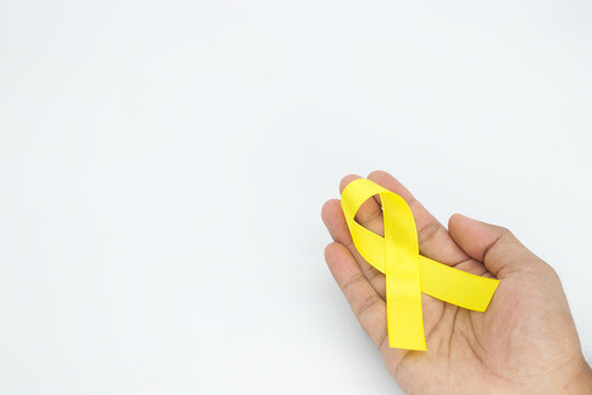 hand holding yellow ribbon on white background,Suicide preventio