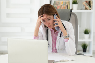 Close up portrait of shocked female doctor sitting at the desktop and working in the office of modern clinic	