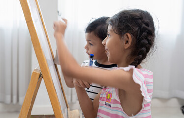 Small boy and his sister draw the white board brother want to take pen from sister's hand