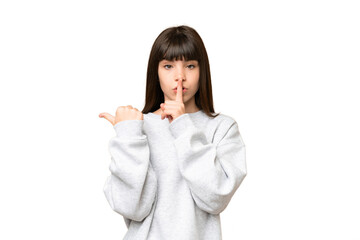 Little girl over isolated green chroma key background pointing to the side and doing silence gesture