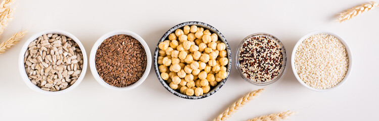 Quinoa, sesame, chickpeas, sunflower seeds and flax seeds in the bowls. Top view. Web banner