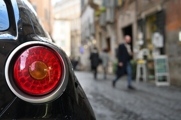 Close-up of taillight, modern car at city street, Rome, Italy