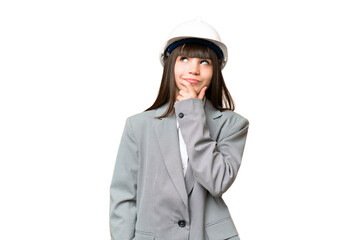 Little girl playing as a architect with helmet and holding blueprints over isolated background...