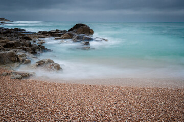 Long exposure of turquoise waves crashing on the beach. Baiona, Galicia, Sapain.
