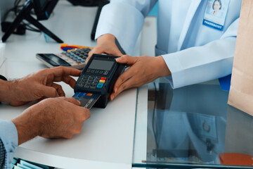 Payment by credit card with payment terminal in qualified drugstore or hospital. Modern payment of...