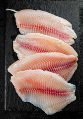 Raw fish fillet on a stone board.