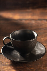 Obraz na płótnie Canvas Empty black coffee cup on rustic wood, dark food style photo, selective focus.