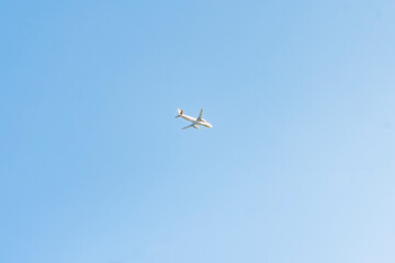A white passenger plane on a blue sky background
