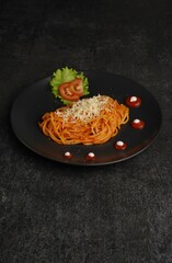 Delicious spaghetti served on a black plate