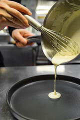 Chef in a restaurant or hotel kitchen cooking sauce