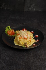 Carbonara pasta on black plate