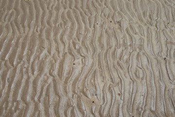 Wavy beach sand texture during daytime, summer travel background