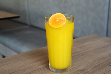 Delicious homemade juice recipe, glass of fresh squeezed orange juice topped with sliced ​​orange.