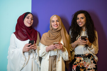 Group portrait of beautiful muslim women two of them in fashionable dress with hijab isolated on...