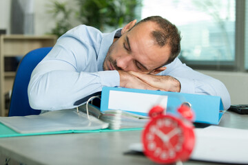 young man sleeping at his desk