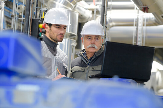 experienced senior engineer consults young designer in factory