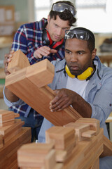 mature workers sanding wood pieces