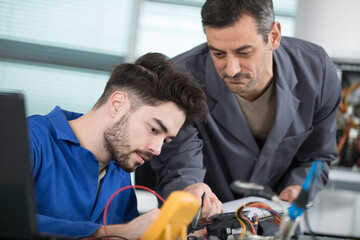 student in electrical engineering course training with teacher