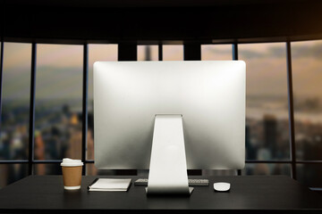 Workspace computer putting on wood working desk and surrounded by coffee cup, clipboard, potted plant, stack of smartphone, tablet, and keyboard  Orderly office. workspace concept..