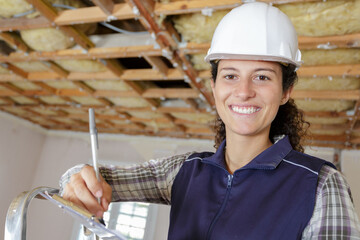 woman using drill on ladder